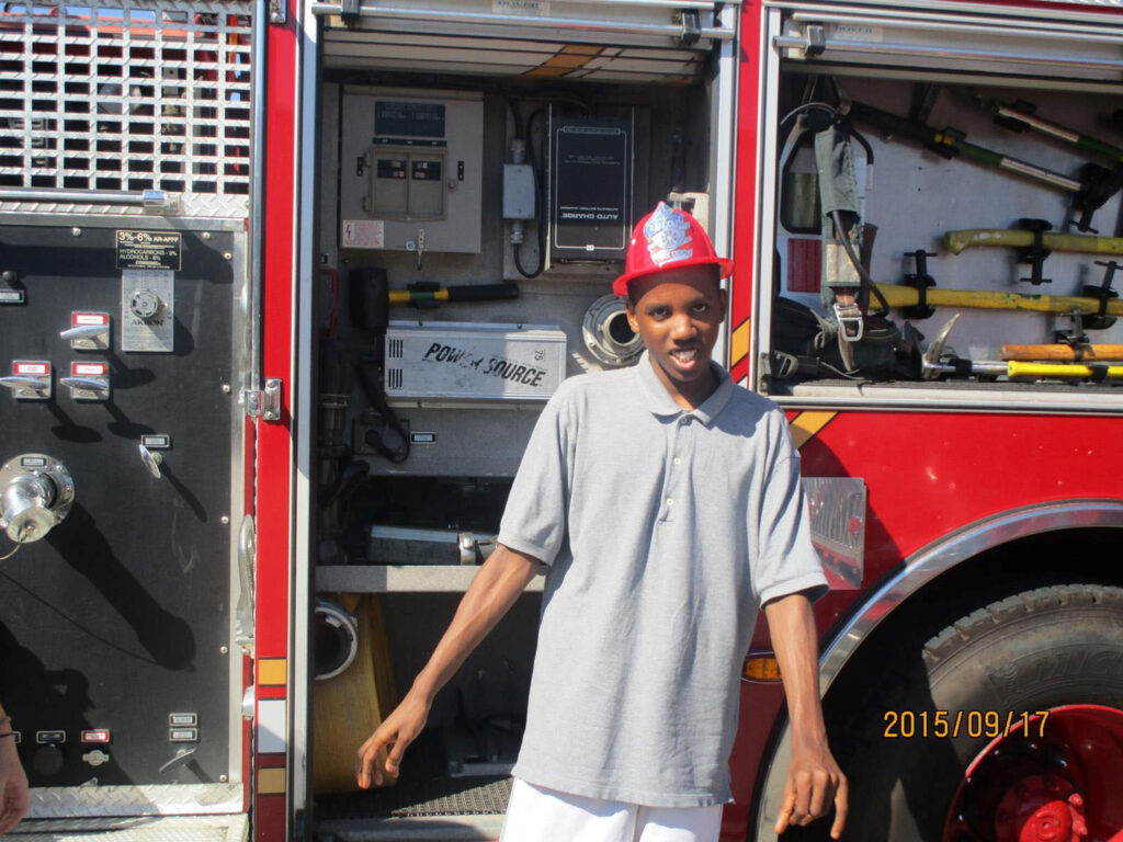 A student poses in front of a fire engine.