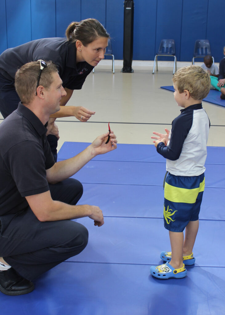 Two firefighters talk to a young boy during the 2015 Safety Day.