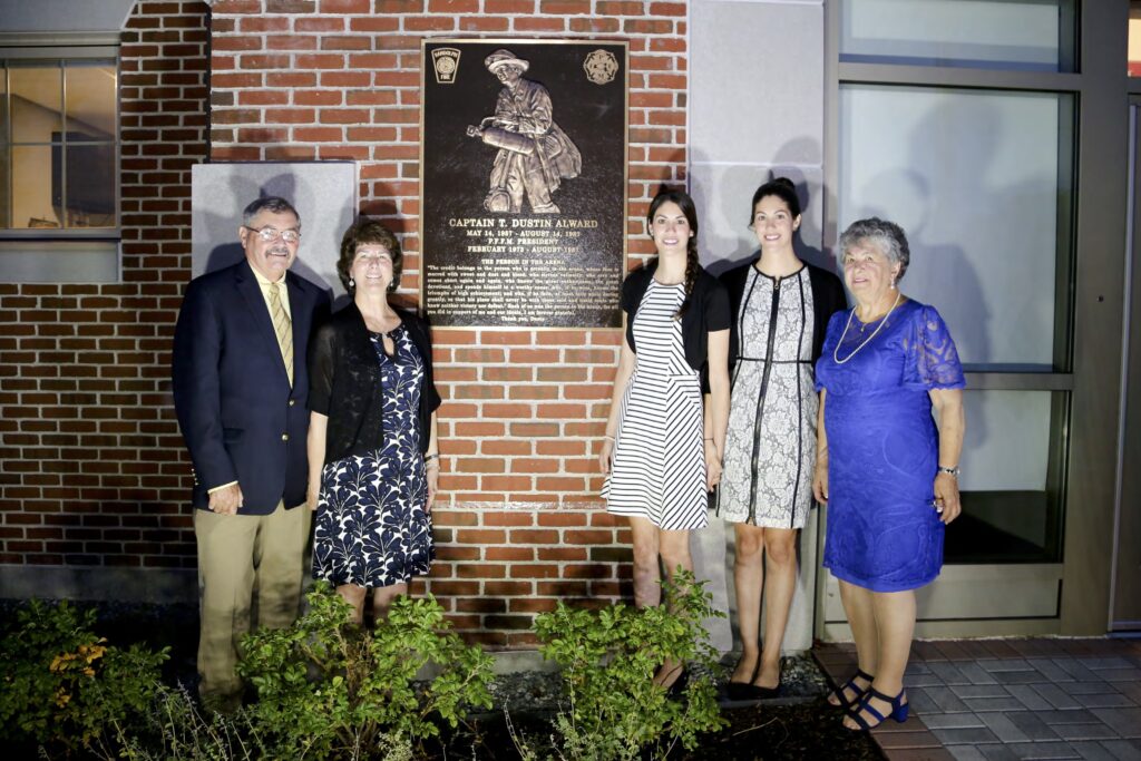Family members next to the dedication for Captain T. Dustin Alward.