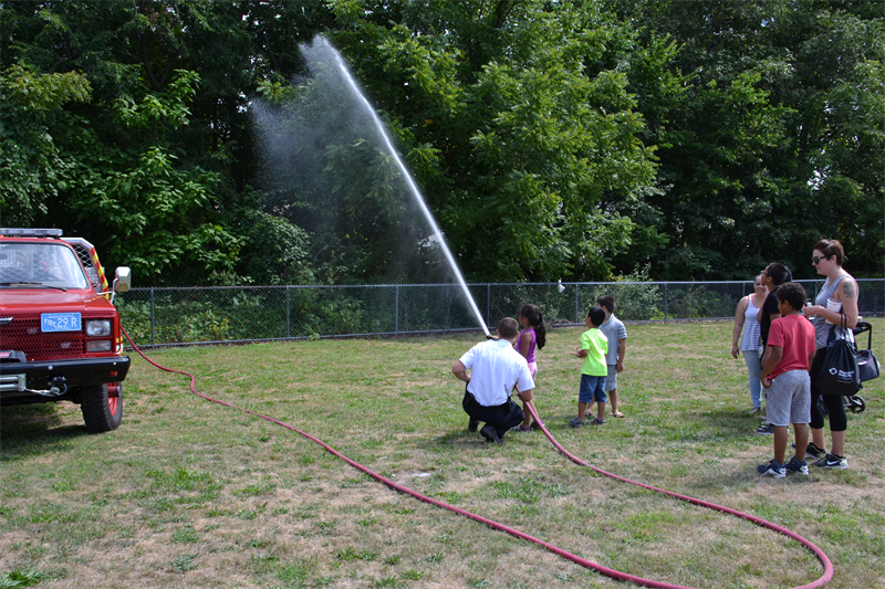 A fire fighter demonstrates a hose during the 2018 back to school jamboree.